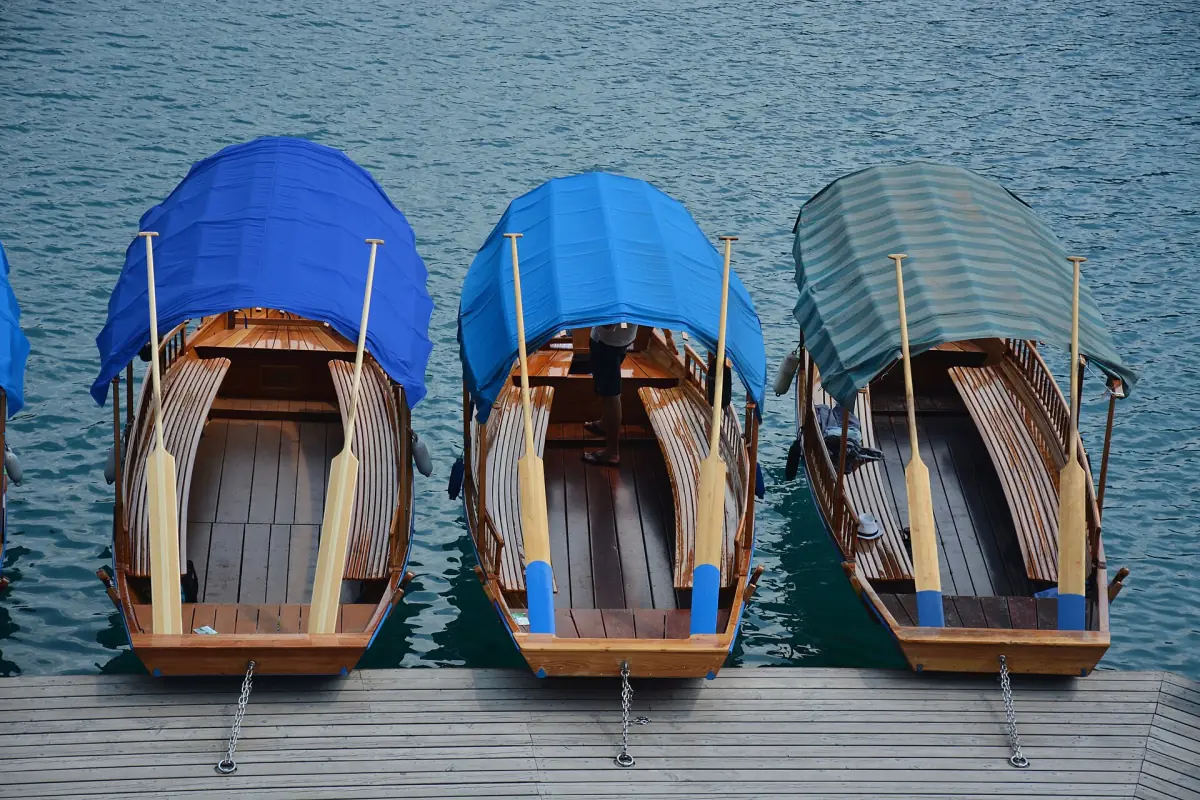 Three pletna boats moored at the shore